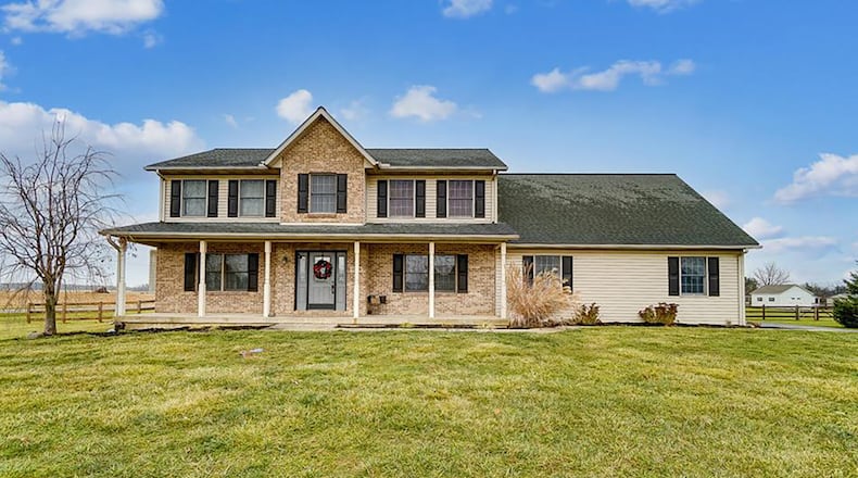 The front of the traditional, brick and vinyl two story home has a full covered front porch and an attached, two-car side entry garage. Contributed photos