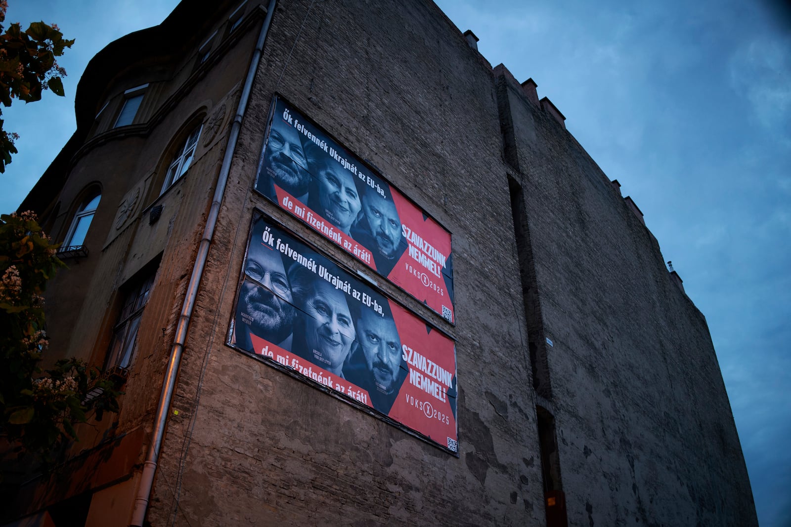 A Hungarian government billboard, opposing Ukraine's EU membership, showing, from left, the leader of the European People's Party Manfred Weber, European Commission President Ursula von der Leyen and Ukrainian President Volodymyr Zelenskyy which reads "They would bring Ukraine into the EU, but we would pay the price! Let's vote no!", is placed on a building In Budapest, Hungary, Monday, June 16, 2025. (AP Photo/Bela Szandelszky)