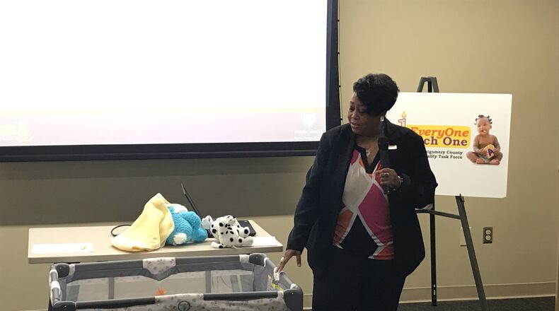 Angela Grayson with Public Health - Dayton & Montgomery County demostrates safe sleep practices. KAITLIN SCHROEDER