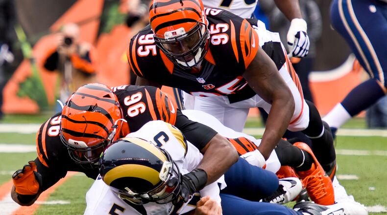 Cincinnati Bengals defensive end Carlos Dunlap (96) and Wallace Gilberry (95) sack St. Louis quarterback Nick Foles during their 31-7 win over the Rams Sunday, Nov. 29 at Paul Brown Stadium in Cincinnati. NICK GRAHAM/STAFF