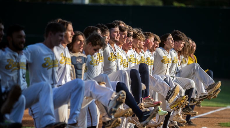 FILE- The Savannah Bananas line up along the first base line to perform a kick-line dance before a Coastal Plain League baseball game against the Florence Flamingos, June 7, 2022, in Savannah, Ga. (AP Photo/Stephen B. Morton, File)