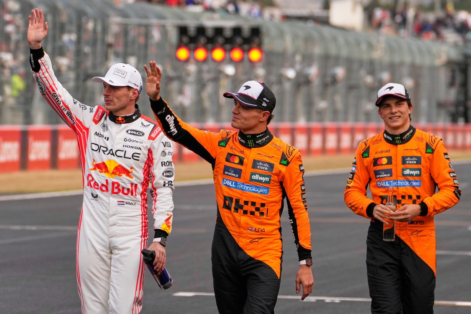 Red Bull driver Max Verstappen of the Netherlands, left, is accompanied with McLaren driver Lando Norris of Britain, center, and McLaren driver Oscar Piastri of Australia, right, after qualifying session for the Japanese Formula One Grand Prix at the Suzuka Circuit in Suzuka, central Japan, Saturday, April 5, 2025. (AP Photo/Hiro Komae)