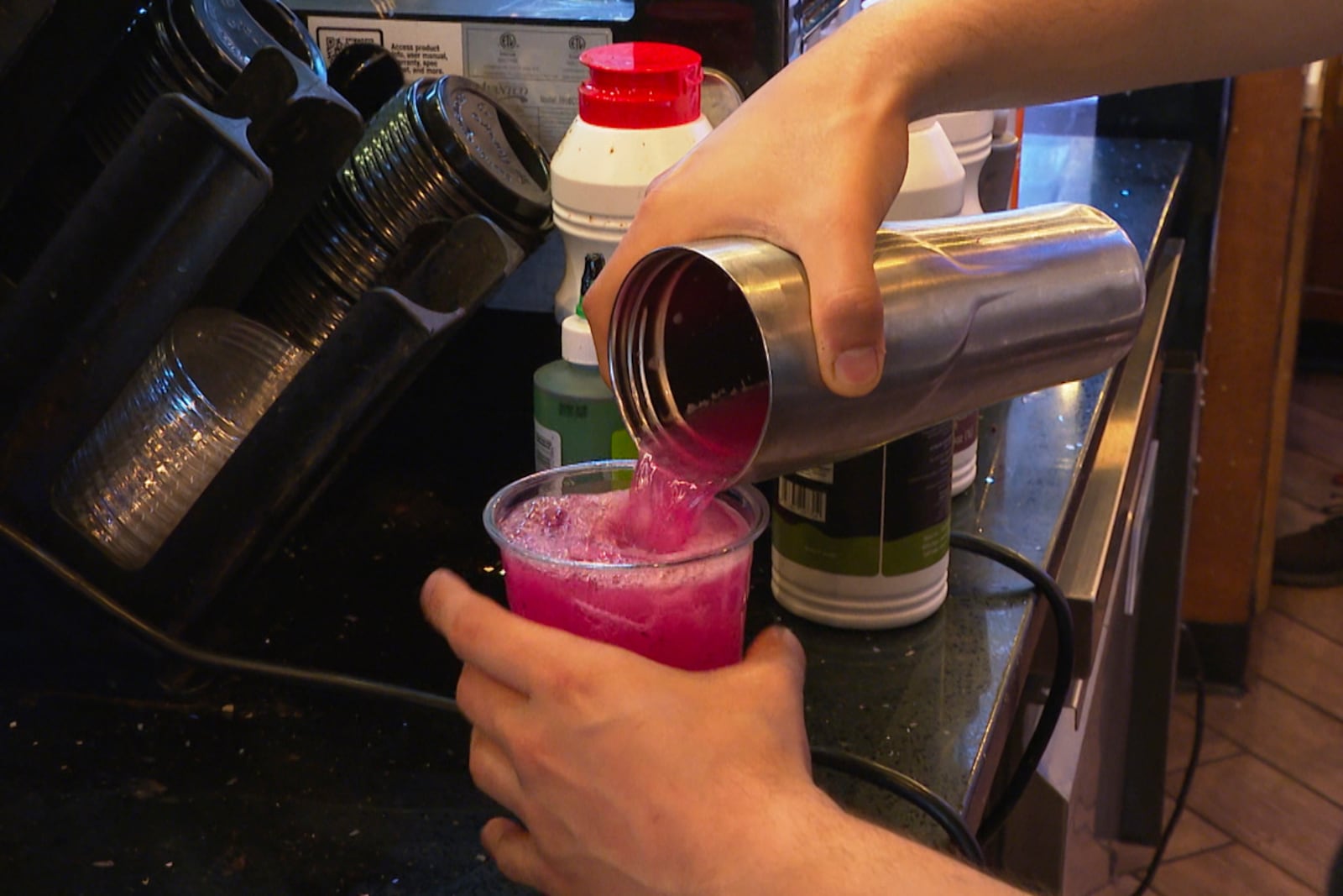 In this image made from video, a Haraz Coffee House employee makes a drink Monday, June 9, 2025, in Dearborn, Mich. (AP Photo/Mike Householder)