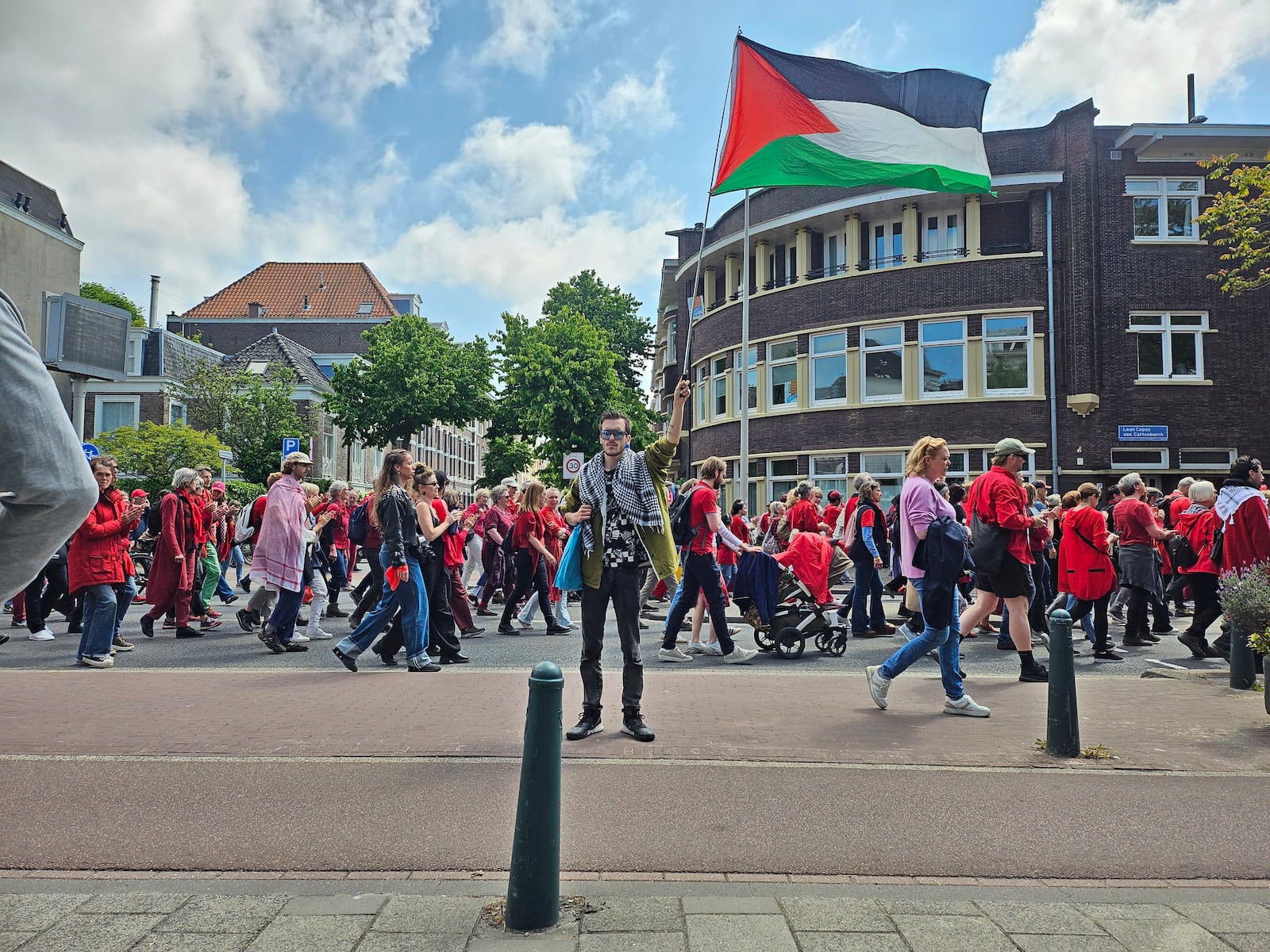 A demonstrator holds a Palestinian flag during the Red Line protest in The Hague, Netherlands on Sunday, May 18, 2025. (Niels van der Pas via AP)