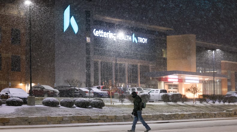 A man crosses West Main Street in Troy on Saturday, Jan. 24, 2026. By 10 a.m. Sunday, the Miami Valley region was experiencing around 12 inches of snow in some areas. BRYANT BILLING/STAFF