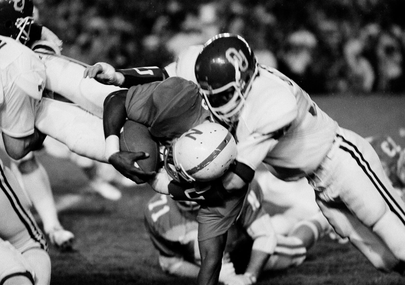 FILE - Nebraska's I.M. Hipp, center, is upended by University of Oklahoma defenders during the second quarter of the Orange Bowl college football game in Miami, Fla., Jan. 1, 1979. (AP Photo/Trainor, File)