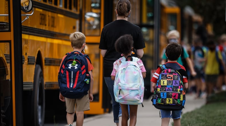 Children at Cline Elementary School in Centerville load into buses after the first day of school Wednesday August 18, 2021. All of the kids were wearing masks. JIM NOELKER/STAFF
