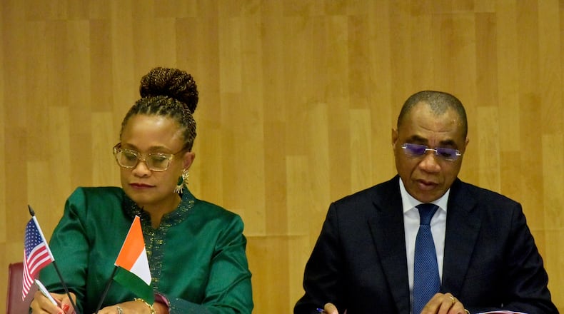 U.S. Ambassador to the Ivory Coast Jessica Davis Ba, left, and Adam Coulibaly, minister of finance and budget, sign a health agreement in Abidjan, Ivory Coast, Tuesday, Dec. 30, 2025. (AP Photo/Diomande Ble Blonde)