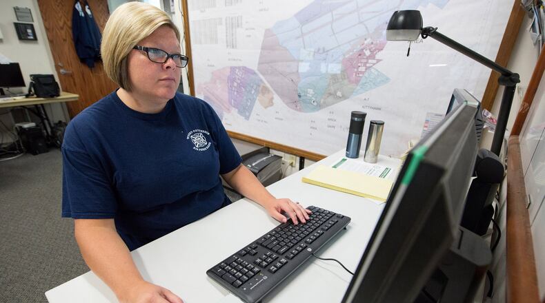 Stephanie Nevin, Wright-Patterson Air Force Base Fire Department emergency vehicle dispatcher, works on GeoBase, a detailed online map that uses a graphical user interface and overlays to allow first responders to see detailed information all around the base Aug. 27. (Common access card digitally covered for security reasons) (U.S. Air Force photo/John Harrington)