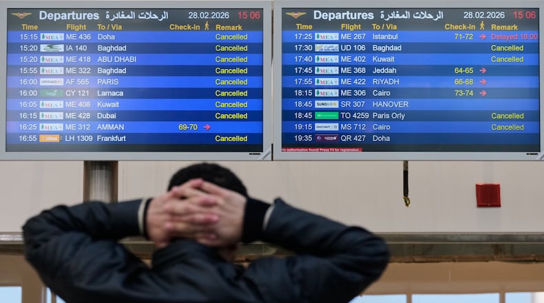 A traveler checks departure times as many flights are cancelled at Beirut Rafik Hariri International Airport in Beirut, Lebanon, Saturday, Feb. 28, 2026, as many airlines canceled flights due to the conflict involving the United States, Israel and Iran. (AP Photo/Hassan Ammar)