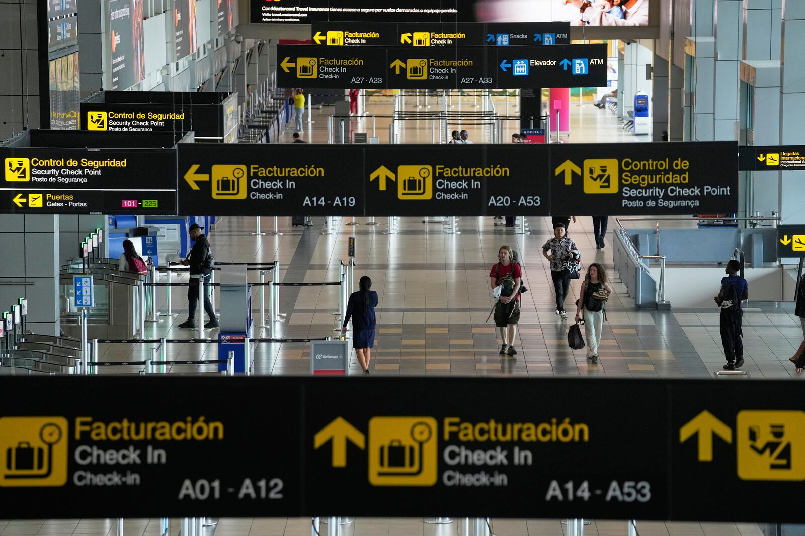 Travelers walk through Tocumen International Airport in Panama City, Thursday, May 22, 2025, as Panama and Venezuela prepare to resume commercial flights nearly a year after suspending them when Panamanian President Jose Raul Mulino refused to recognize the re-election of Venezuelan President Nicolas Maduro. (AP Photo/Matias Delacroix)