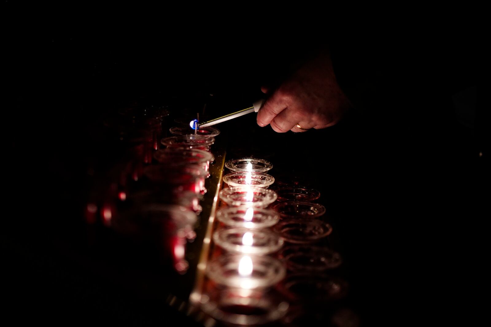 A person lights a candle at Liverpool Metropolitan Cathedral following the announcement by the Vatican of the death of Pope Francis aged 88, in Liverpool, England, Monday, April 21, 2025. (Peter Byrne/PA via AP)