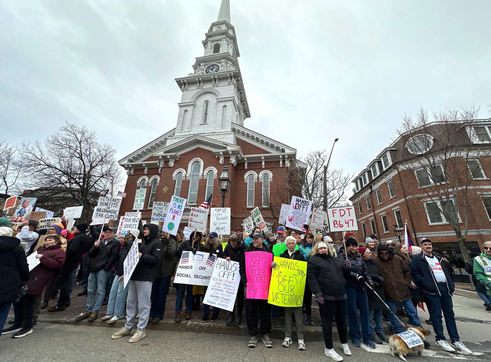 Demonstrators hold signs during a "Hands Off!" protest against President Donald Trump in Portsmouth, N.H., Saturday, April 5, 2025. (AP Photo/Caleb Jones)