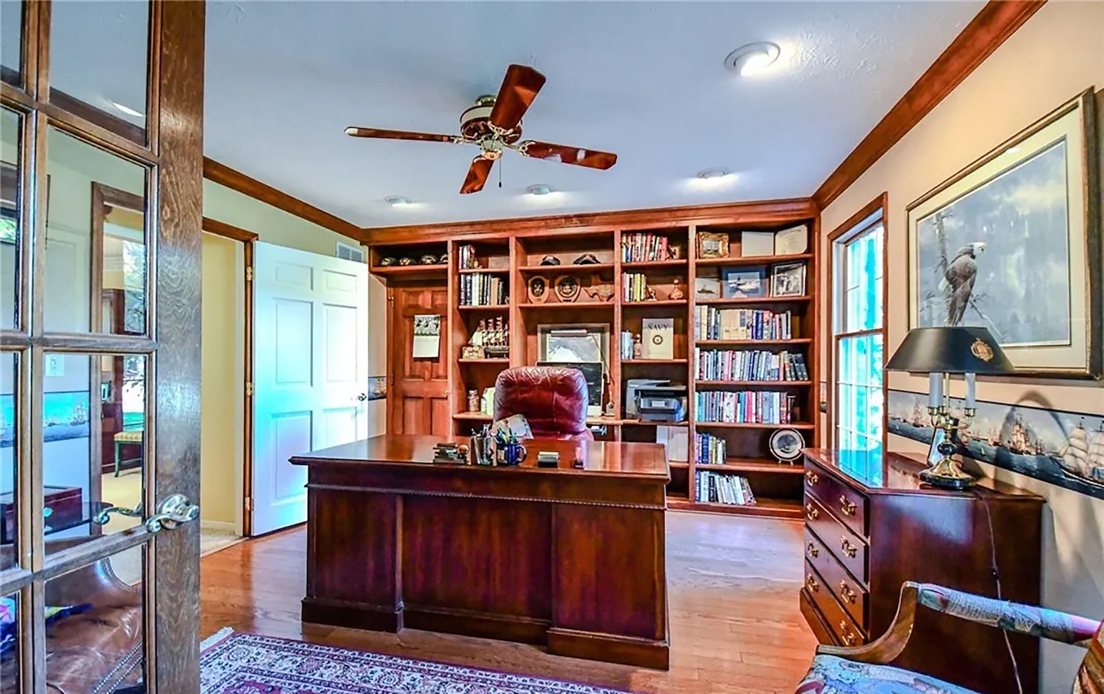 The dedicated home office has crown molding, hardwood floors, a built in bookcase and ceiling fan. CONTRIBUTED