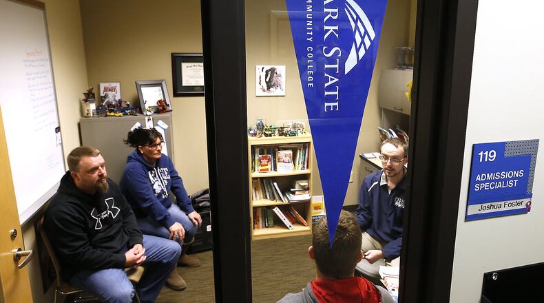 Joshua Foster, an admissions specialist at Clark State Community College, talks to the Watson family about Kage Watson, a high school senior, attending Clark State next year. Bill Lackey/Staff