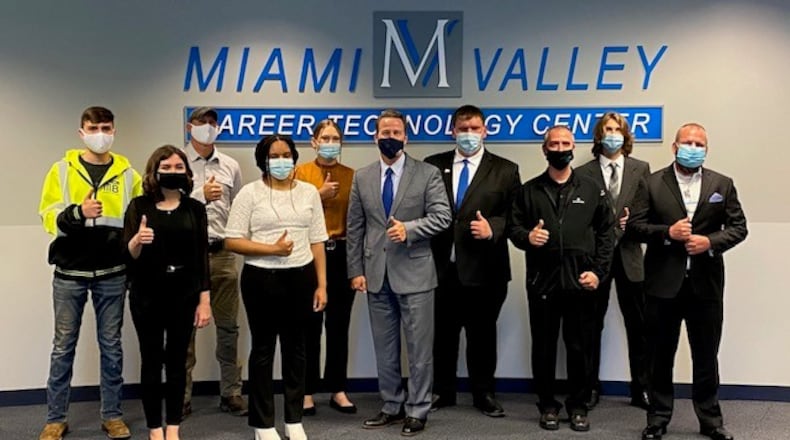 Lieutenant governor, Jon Husted, with six Miami Valley Career Technology College students  and some of their employers discuss why vocational schools are important.