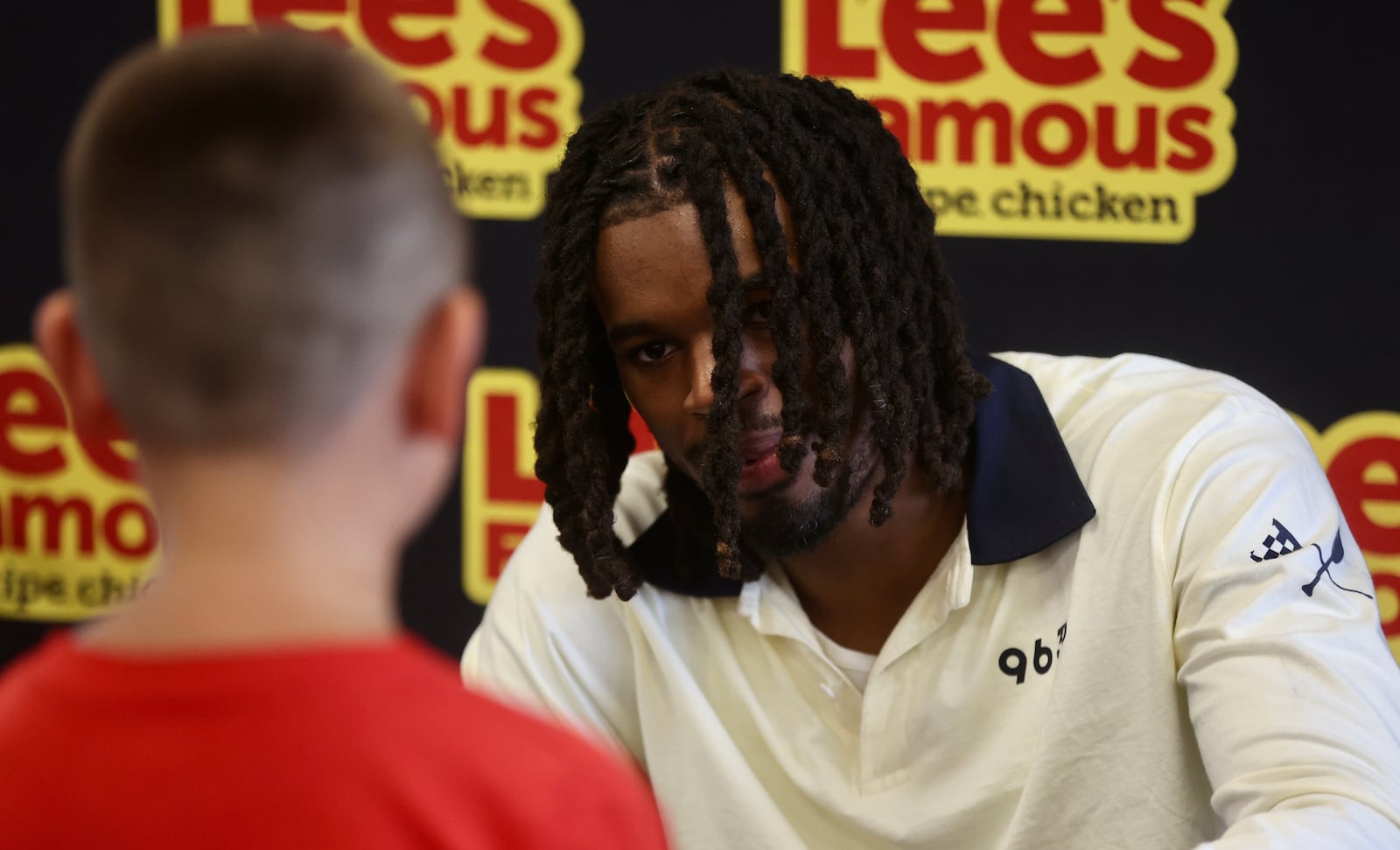 DaRon Holmes II signs autographs for a Dayton fan at Lee's Famous Recipe Chicken in Kettering on Thursday, July 31, 2025. David Jablonski/Staff