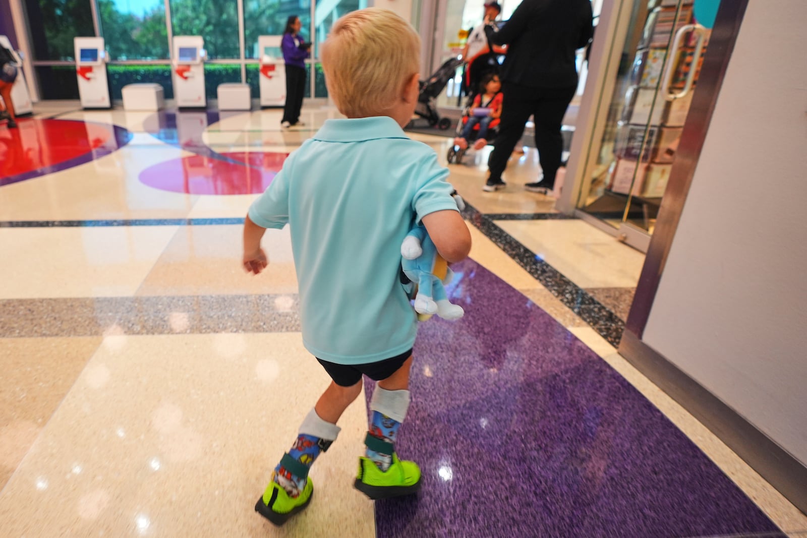 Four-year-old Rustin 'Rusty' Haugh who suffers from Combined Oxidative Phosphorylation Deficiency 11, or COXPD11, walks in a hospital lobby after a doctor's appointment in Dallas, Wednesday, July 23, 2025. (AP Photo/LM Otero)