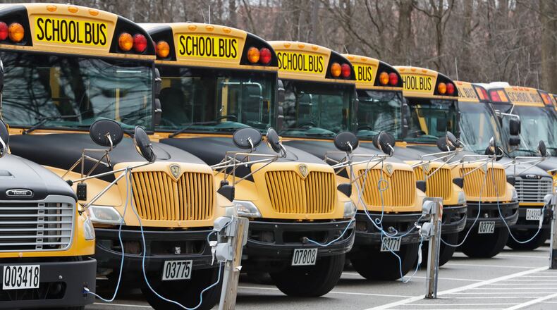 FILE - A row of school buses rests in a parking lot, April 7, 2020, in Cleveland Heights, Ohio. (AP Photo/Tony Dejak, File)