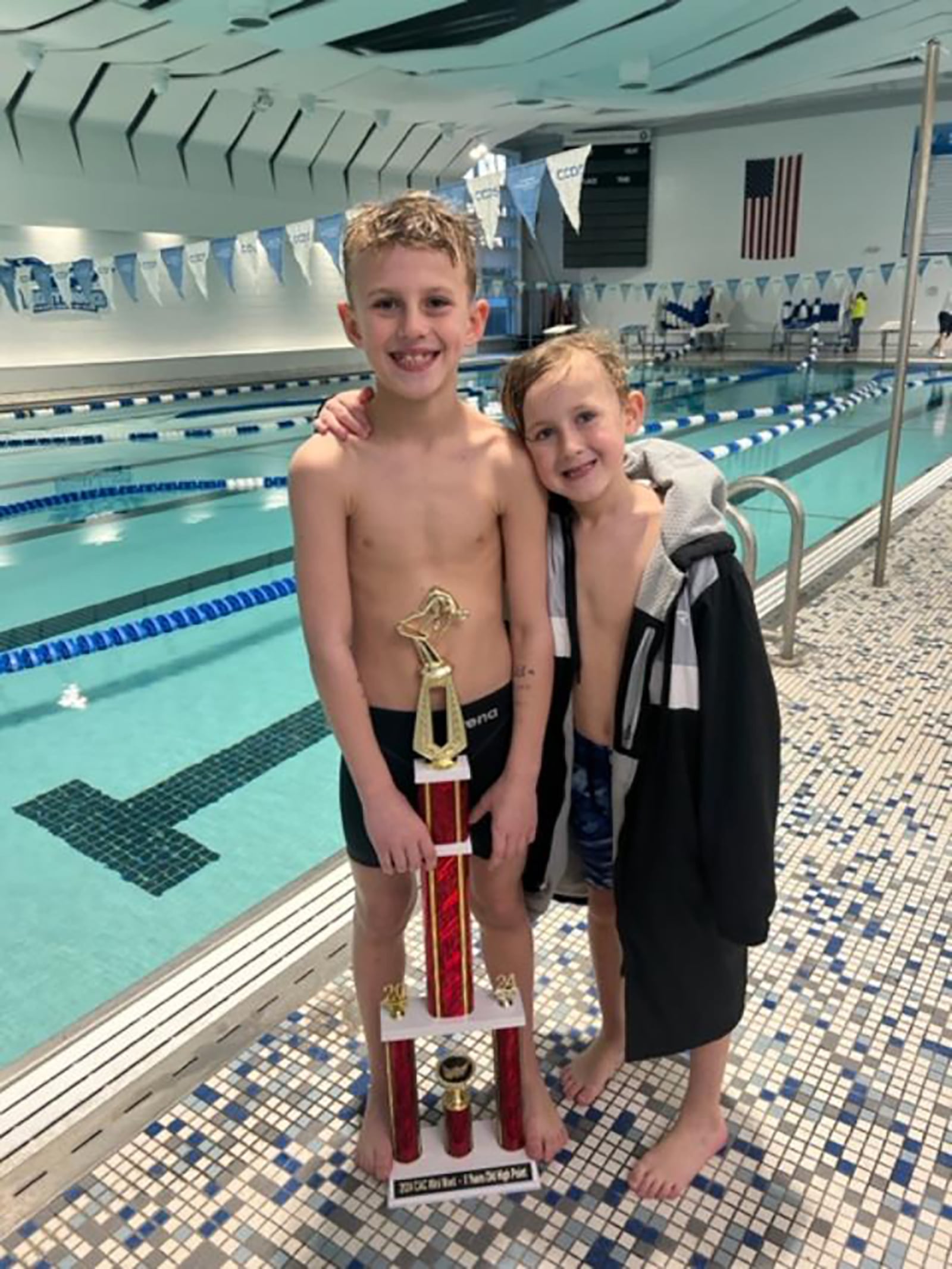 Tyler Gibble, age 8 (Left) with his younger brother Josh, then age 6 with one of Tyler's swimming trophies. CONTRIBUTED