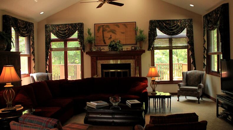 A tall archway creates a covered entrance leading into the grand 2-story entry, where features include cherry hardwood flooring and crown moldings with dentil detailing.