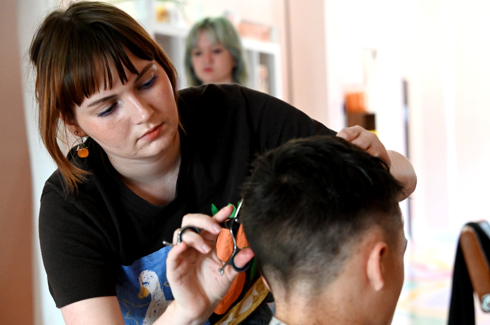 Hue Mane Salon on Pleasant Avenue held a back-to-school hair-cutting event where parents could "Pay What You Can" to get their kids new haircuts ahead of the new school year, which started the week of Aug. 11, 2025, for the Hamilton City School District. Stylists from other salons and Hue Mane participated in the event, which included multiple vendor booths, including Lane Libraries, SELF and Sunrise Treatment Center. Pictured is Hue Mane stylist Jilliana "Jilly" McEvilly, cutting the hair of Nolan Newberry, a 13-year-old who attends Wilson Middle School. MICHAEL D. PITMAN/STAFF