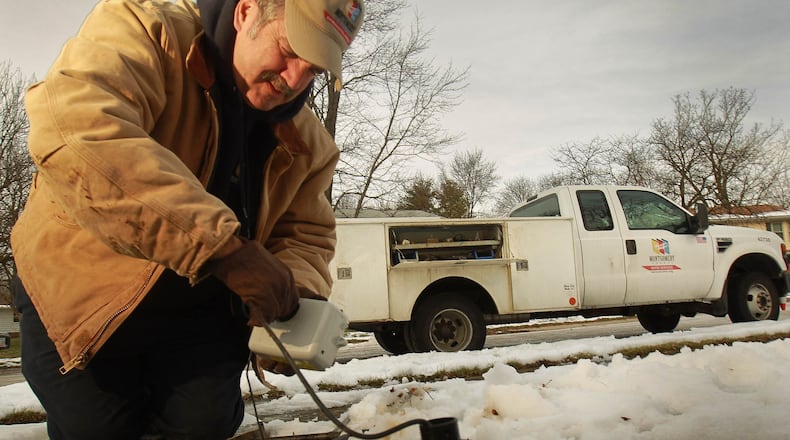 A Montgomery County Environmental Services employee installs a water meter in Riverside in 2013. FILE