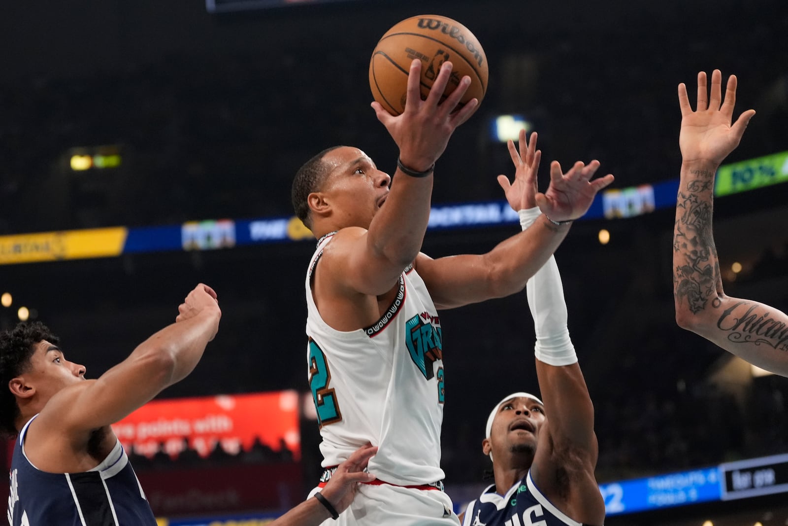 Memphis Grizzlies guard Desmond Bane, center, shoots the ball past Dallas Mavericks defenders during the first half of an NBA play-in tournament basketball game Friday, April 18, 2025, in Memphis, Tenn. (AP Photo/George Walker IV)