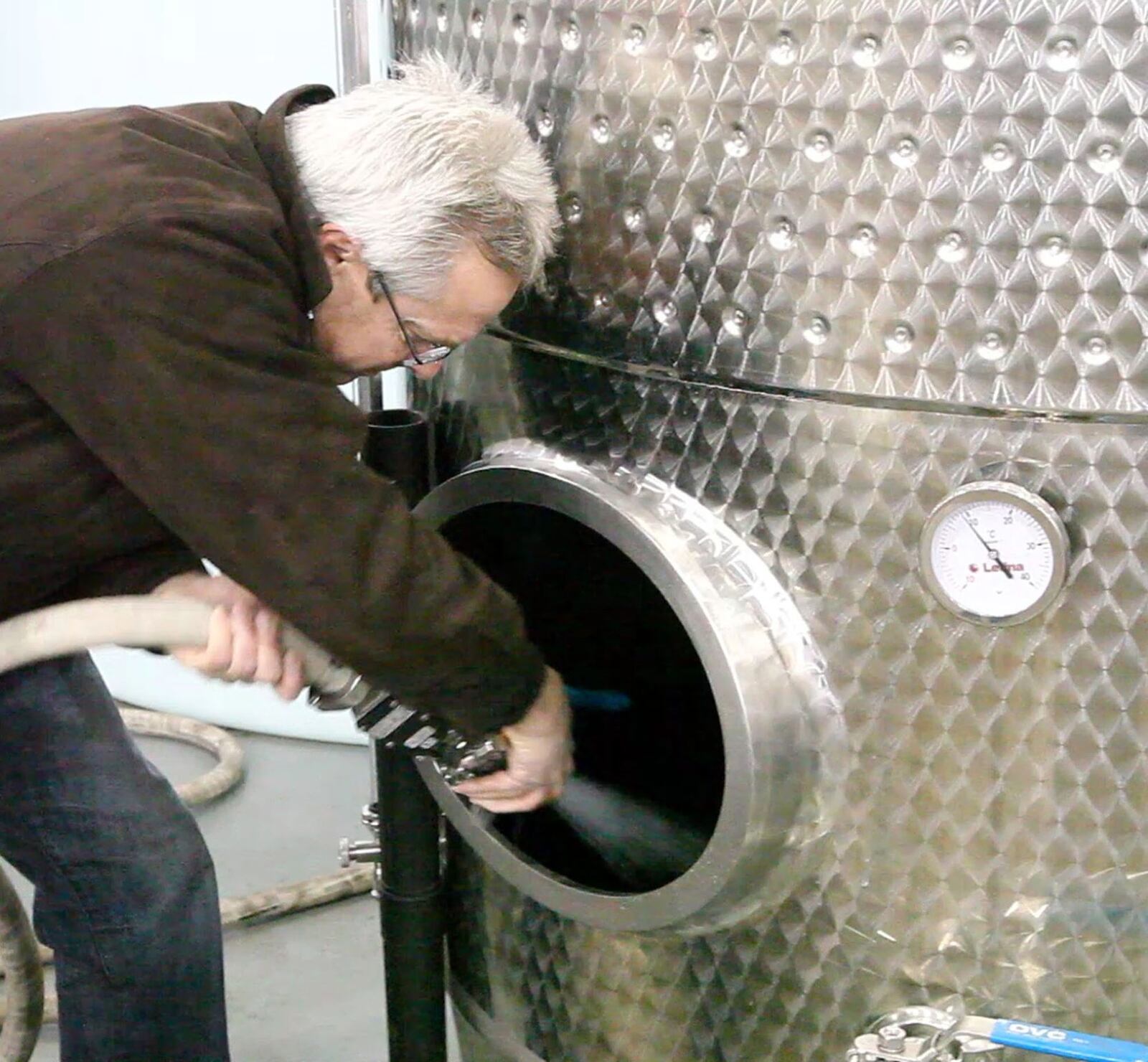 Buckeye Vodka CEO Jim Finke cleans out a tank a the Dayton distillery and warehouse.