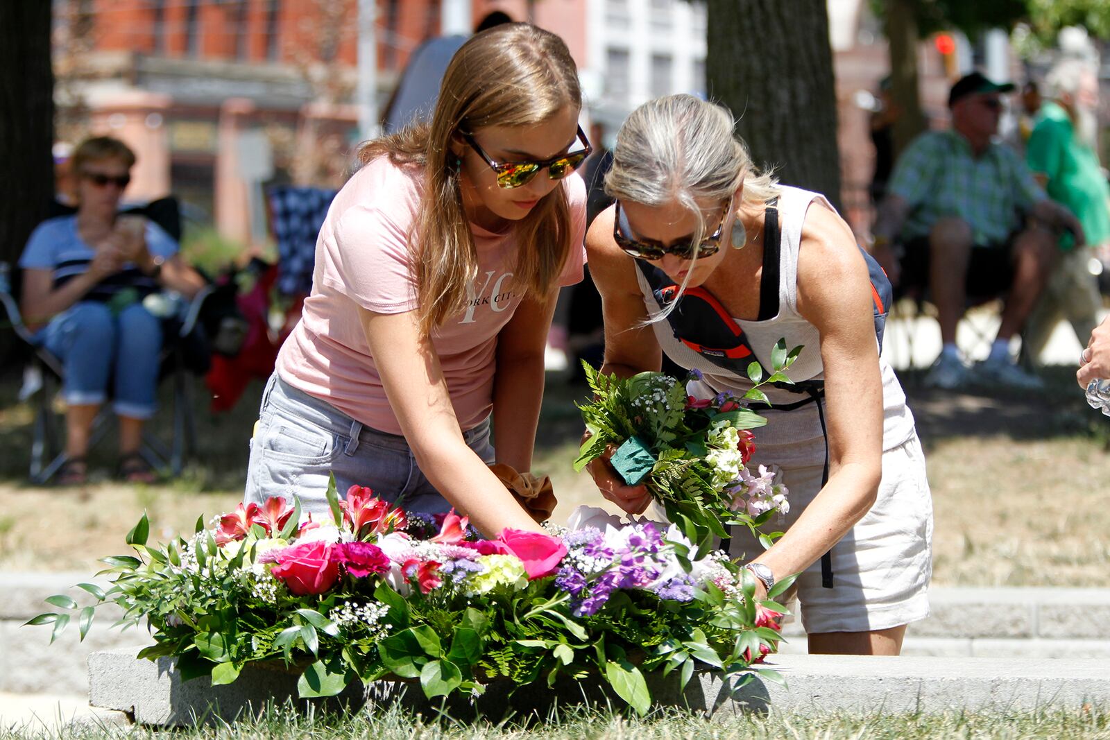 Mackenzie Duff (left) and her mother, Tammy arrange a floral wreath for the prayer vigil held at the Levitt Pavilion Sunday. On their way to the event a car pulled up and a woman handed them the tribute. LISA POWELL / STAFF