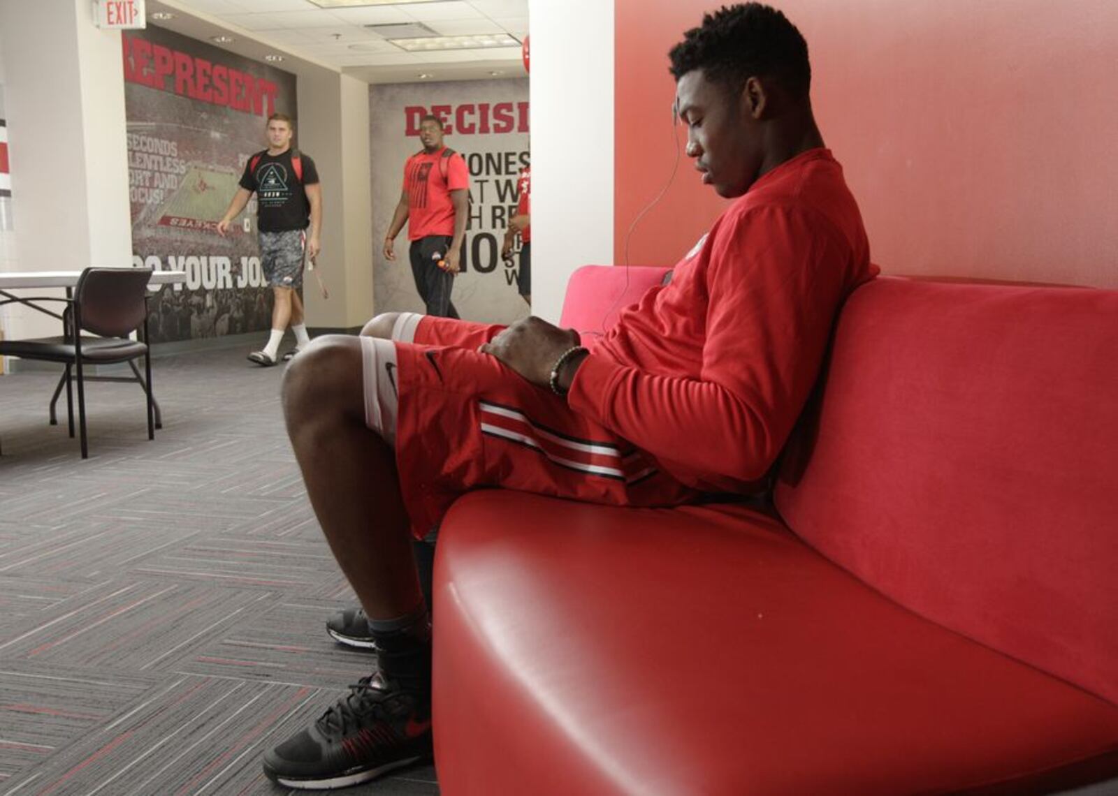In this Sept. 16, 2015, photo, Ohio State linebacker Joshua Perry looks at his phone during his daily biometrics monitoring before practice in Columbus, Ohio. Ohio State uses the device to track overall physiological readiness of players and how they hold up to the wear and tear of football. (AP Photo/Jay LaPrete)