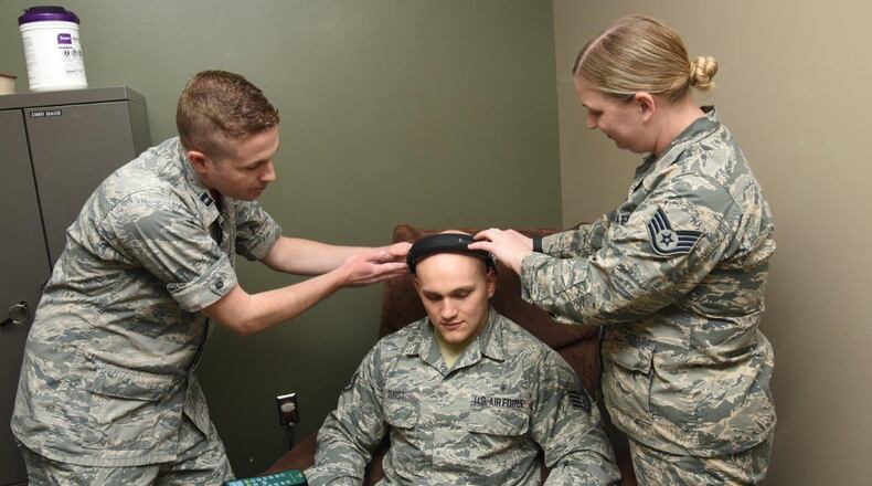 Capt. Daniel Gibson, 92nd Medical Operation Squadron psychologist, and Staff Sgt. Marisa Prokarym, 92nd Medical Operation Squadron NCOIC, Alcohol Drug Abuse Prevention Treatment, place a Nexxus Biotrace headpiece on Staff Sgt. Donald Durst, 92nd Aerospace Medicine Squadron aerospace medical technician, May 4 at Fairchild AFB, Washington. The equipment allows patients to see how their body is responding to both physical and mental stress. (U.S. Air Force photo/Staff Sgt. Samantha Krolikowski)