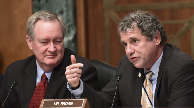 Senate Banking, Housing and Urban Affairs Committee ranking member Sen. Sherrod Brown, D-Ohio, right, sitting next to committee chairman Sen. Mike Crapo, R-Idaho, left, asks a question of Wells Fargo Chief Executive Officer Timothy Sloan on Capitol Hill in Washington, Tuesday, Oct. 3, 2017. (AP Photo/Susan Walsh)