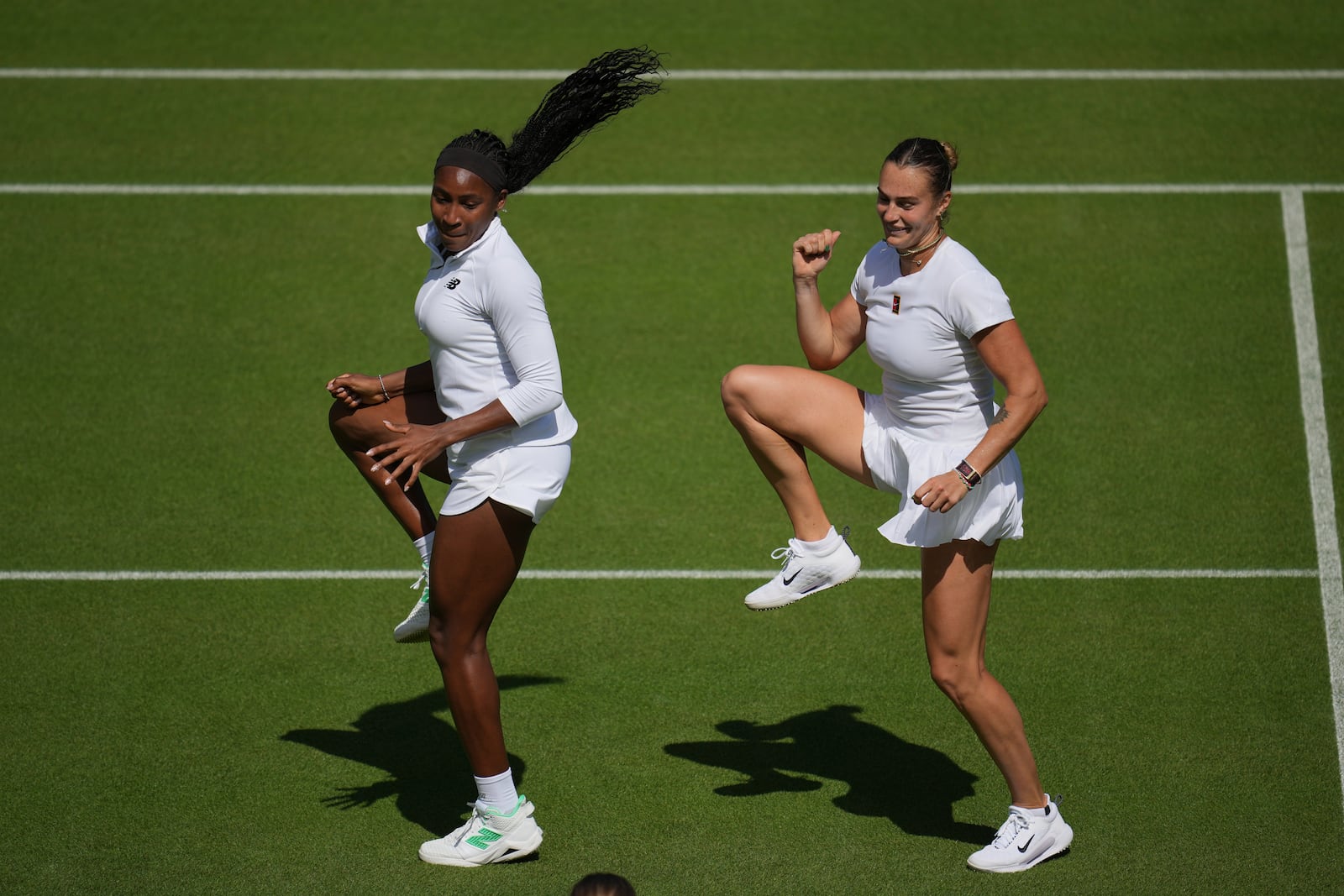 Aryna Sabalenka of Belarus, right, and Coco Gauff of United States dance during a practice session ahead of the Wimbledon Championships in London, Friday, June 27, 2025. (AP Photo/Kin Cheung)