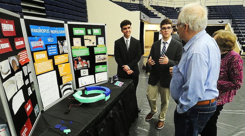 Kettering Fairmont students, from left, Husam Alboush and Zach Lehman talk with Jack and Bobbie Lehman about their Kwadropus Propulsion Belt project Monday, March 4, 2024 at the NASA HUNCH's Critical Design Review at Trent Arena. MARSHALL GORBY\STAFF