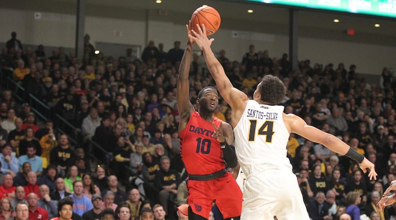 Dayton’s Jalen Crutcher throws a pass to Josh Cunningham but commits a turnover in the final minutes against Virginia Commonwealth on Wednesday, Jan. 16, 2019, at the Siegel Center in Richmond, Va.