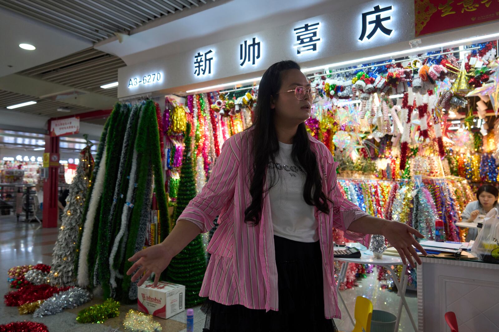 Ding Dandan, who runs Christmas decorations exports, speaks outside her store at the Yiwu International Trade Market in Yiwu, eastern China's Zhejiang province on Thursday, April 10, 2025. (AP Photo/Ng Han Guan)