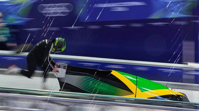 Jamaica's Mica Moore starts for a women's monobob training session at the 2026 Winter Olympics, in Cortina d'Ampezzo, Italy, Friday, Feb. 13, 2026. (AP Photo/Alessandra Tarantino)