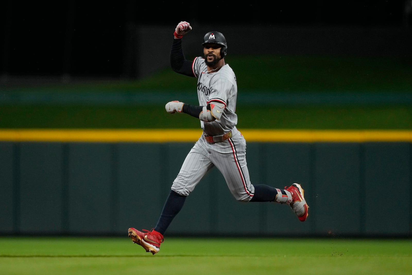 Minnesota Twins' Byron Buxton celebrates hitting a solo home run as he rounds the bases in the first inning of a baseball game against the Cincinnati Reds, Wednesday, June 18, 2025, in Cincinnati. (AP Photo/Carolyn Kaster)