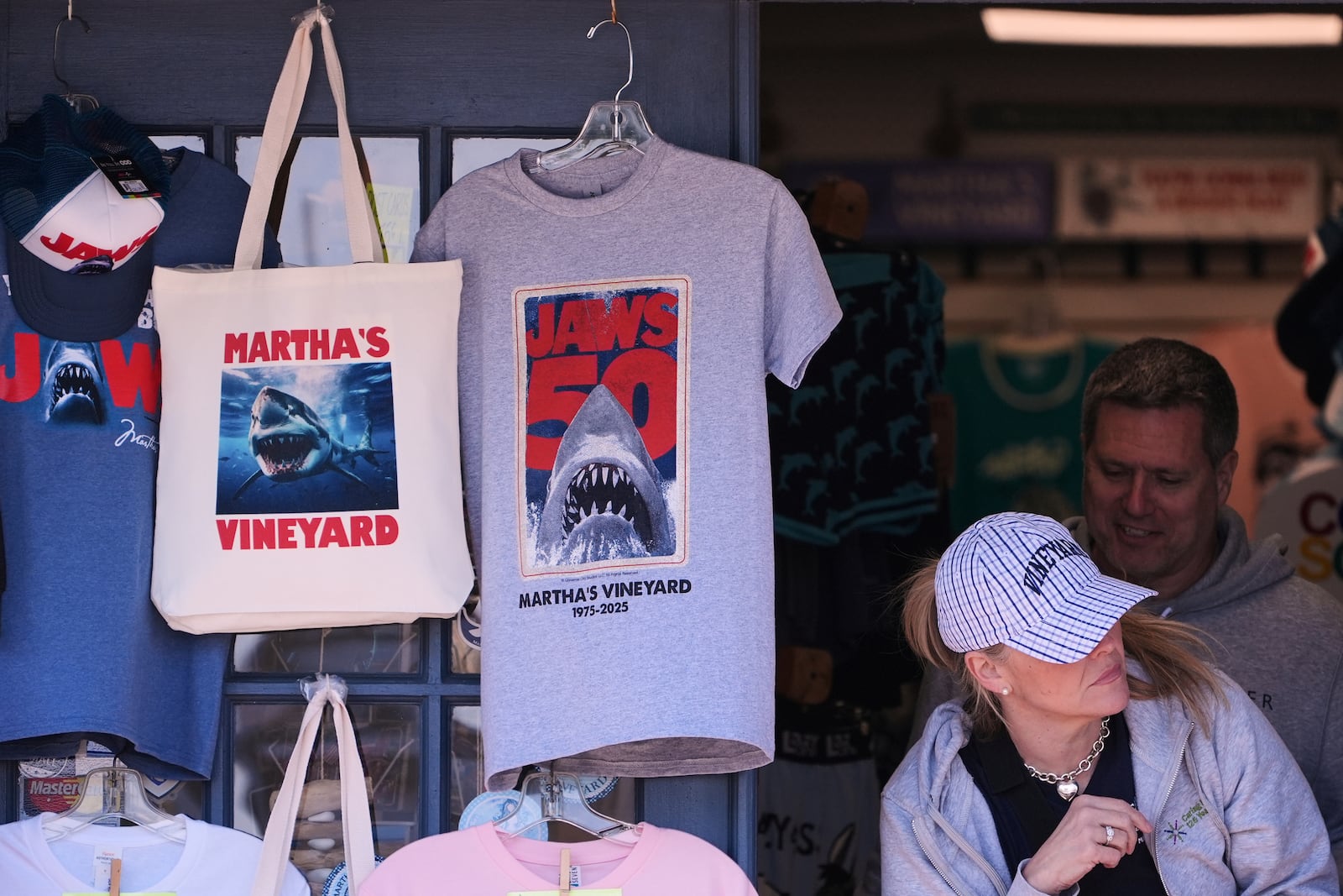 A shopper walks past items featuring the Jaws movie at Neptune's Sea Chest gift shop, Monday, May 12, 2025, in Vineyard Haven, Mass., on Martha's Vineyard Island. (AP Photo/Charles Krupa)