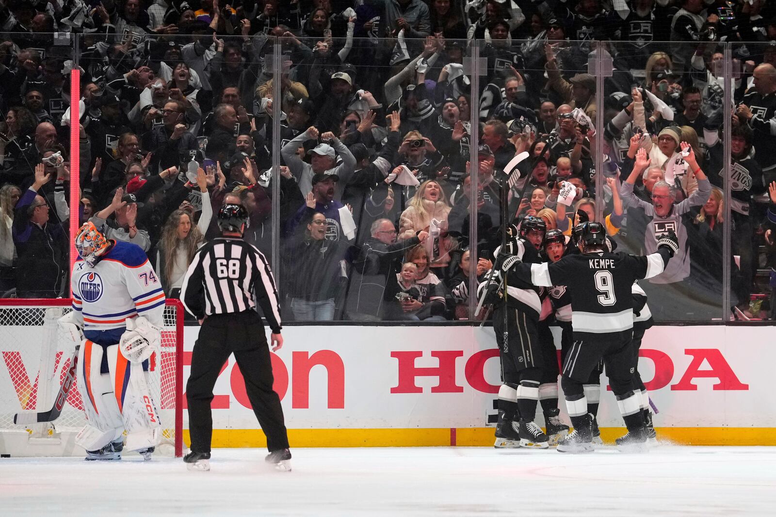 Members of the Los Angeles Kings, right, celebrate a goal by left wing Andrei Kuzmenko as Edmonton Oilers goaltender Stuart Skinner stands in goal during the first period in Game 1 of an NHL hockey first-round playoff series Monday, April 21, 2025, in Los Angeles. (AP Photo/Mark J. Terrill)