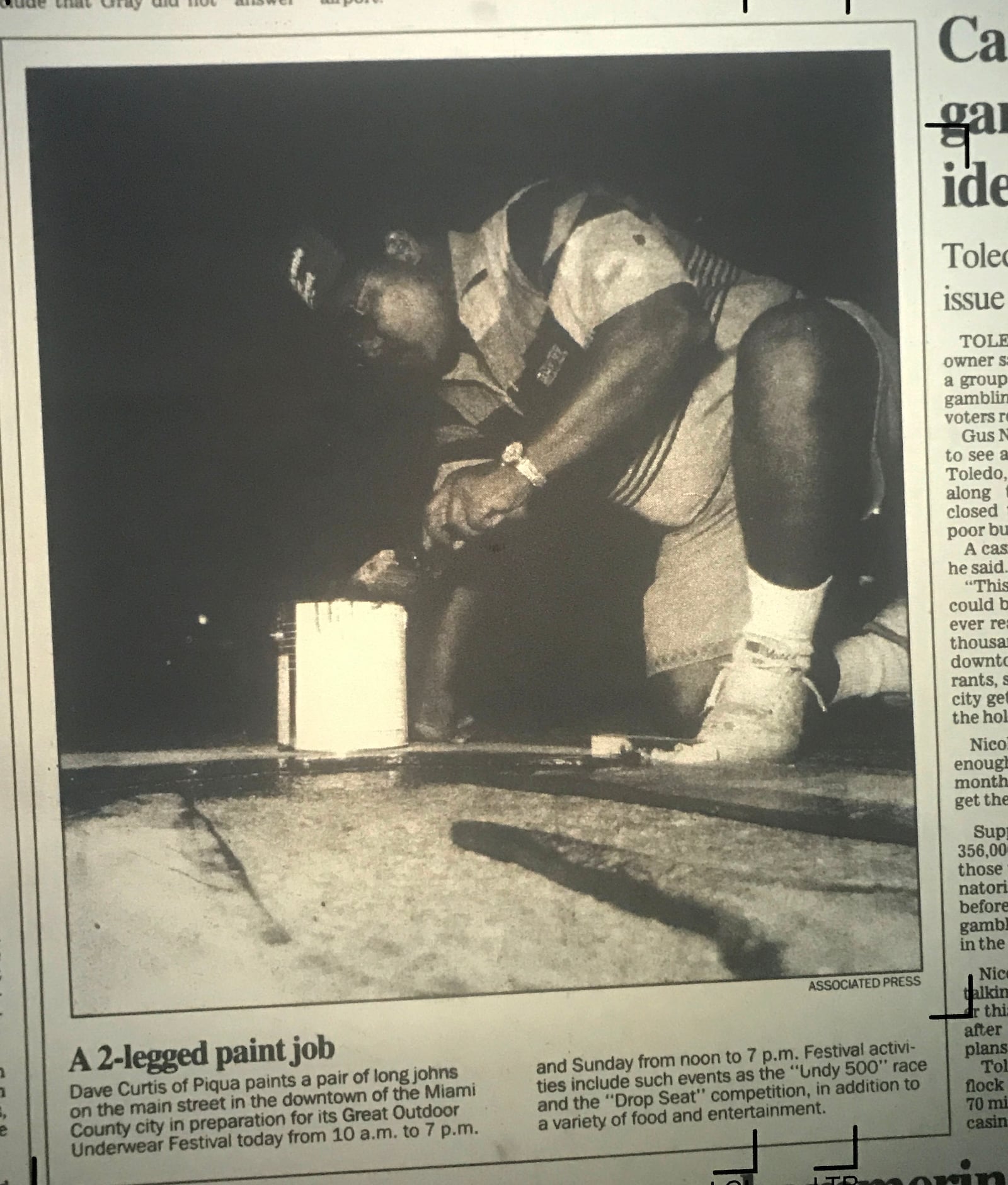 This photo ran in the Dayton Daily News  Saturday, Oct. 10 1992 with the caption: Dave Curtis of Piqua paints a pair of long johns on the main street in the downtown of the Miami County city in preparation for its Great Outdoor Underwear Festival today from 10 a.m. to 7 p.m. and Sunday from noon to 7 p.m. Festival activities include such events as the "Undy 500" race and the "Drop Seat" competition, in addition to a variety of food and entertainment.