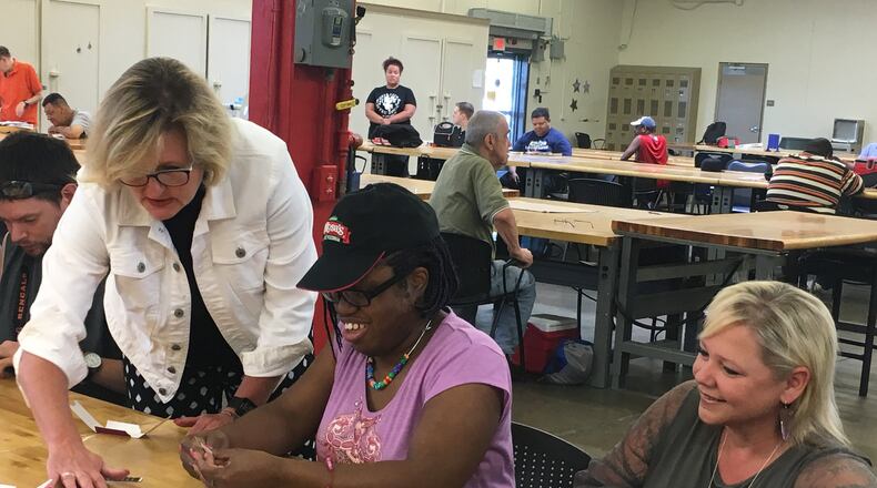 Tempagenix owners April Pollock and Shelly Heller package their paper thermometers Temp-N-Toss with workers at the Better Living workshop in Old North Dayton. Better Living hires individuals with disabilities to assemble products for area businesses. STAFF PHOTO / HOLLY SHIVELY