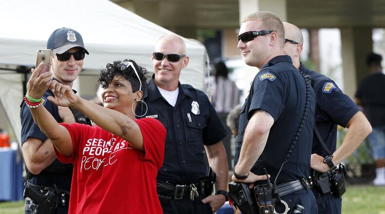 Penelope Brown of Dayton takes a selfie with a group of Dayton Police officers Tuesday night at Residence Park during National Night Out activities. “I’m proud of Dayton’s finest, they did awesome work,” Brown said. “If there is any light in all of this darkness it’s the Dayton Police Department.” The officers are (left to right) Officer Randy Betsinger, Officer Mark Orick, Officer Michael Schwartz and Officer Luke Scott. LISA POWELL / STAFF