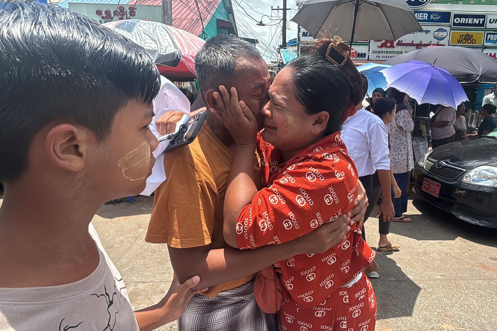 A released prisoner, center, is welcomed by family members outside the main gate of Insein prison as the head of Myanmar’s military government granted amnesty to thousands of prisoners to mark the country's traditional New Year Thursday, April 17, 2025, in Yangon, Myanmar. (AP Photo/Thein Zaw)