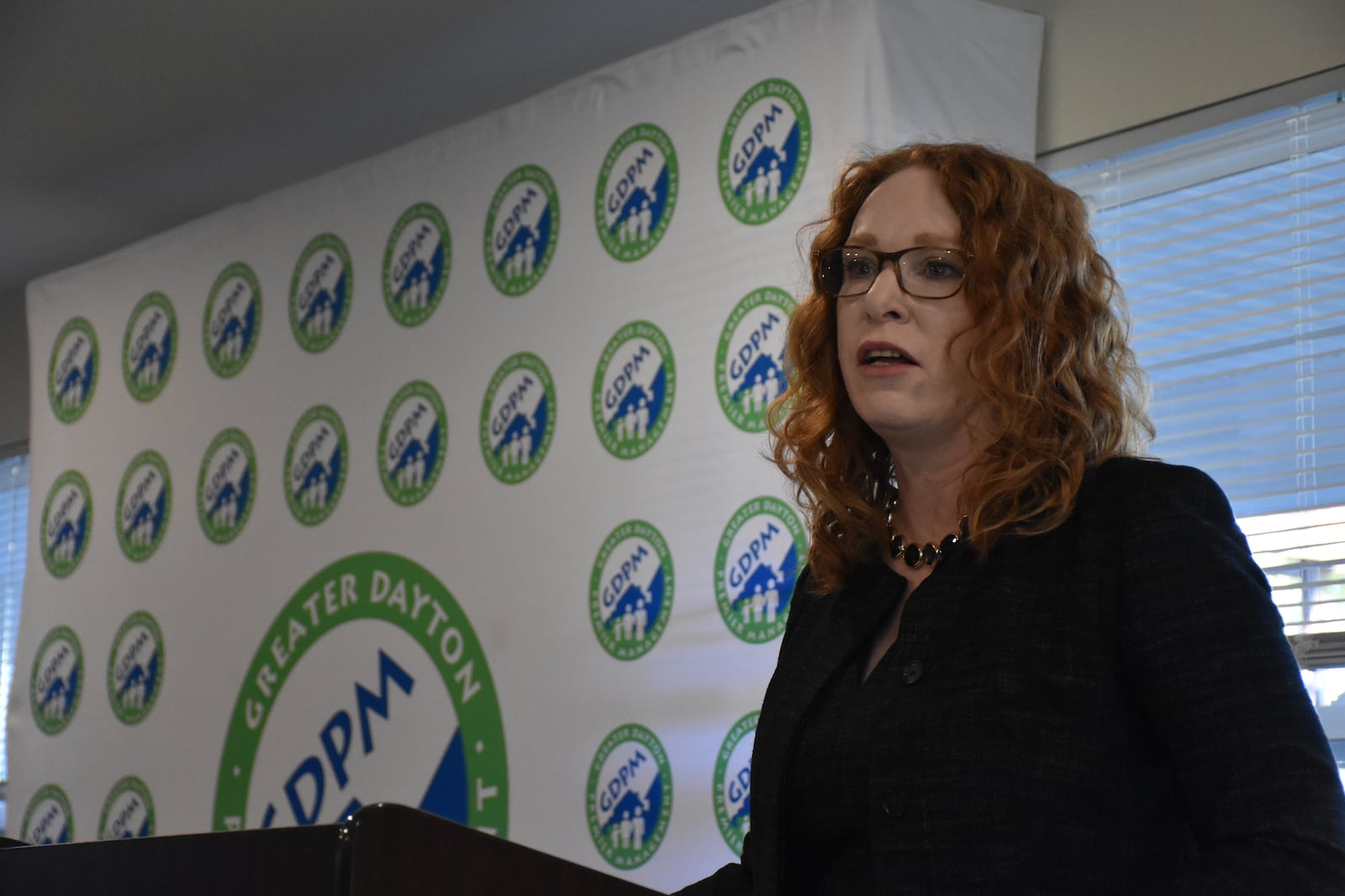 Jennifer Heapy, CEO of Greater Dayton Premier Management (GDPM), speaks at a ribbon-cutting event for Germantown Crossing, a new apartment building in West Dayton. CORNELIUS FROLIK / STAFF