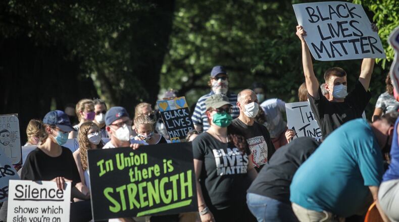 Many who attended the Black Lives Matter rally at Oakwood’s Wright Memorial Public Library Thursday night lined Far Hills Avenue carrying signs to help spread their message. JIM NOELKER/STAFF