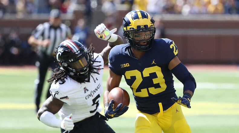 ANN ARBOR, MI - SEPTEMBER 9: Michigan’s Tyree Kinnel, a Wayne High School graduate, intercepts the ball and scores a first quarter touchdown as Mike Boone of the Cincinnati Bearcats gives chase at Michigan Stadium on September 9, 2017 in Ann Arbor, Michigan.(Photo by Leon Halip/Getty Images)