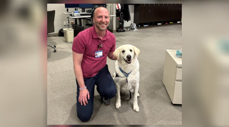 Kettering Health Operations Command Center Nursing Supervisor Nik Saxon visits with Nick from the Miami Valley Pet Therapy Association. CONTRIBUTED