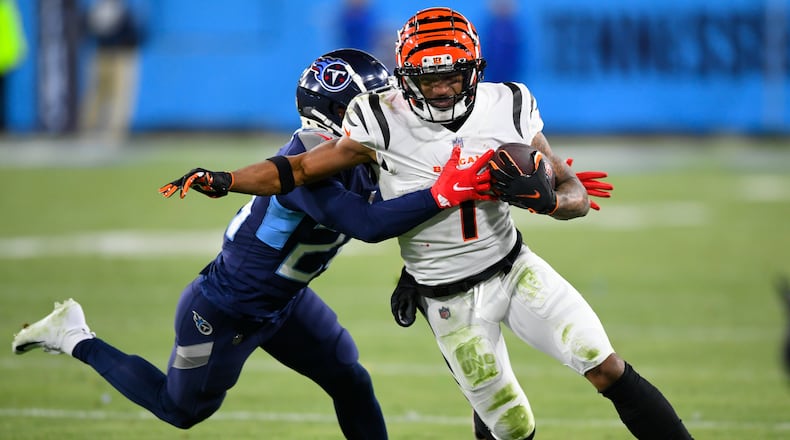 Tennessee Titans cornerback Janoris Jenkins (20) tackles Cincinnati Bengals wide receiver Ja'Marr Chase (1) during the second half of an NFL divisional round playoff football game, Saturday, Jan. 22, 2022, in Nashville, Tenn. (AP Photo/John Amis)